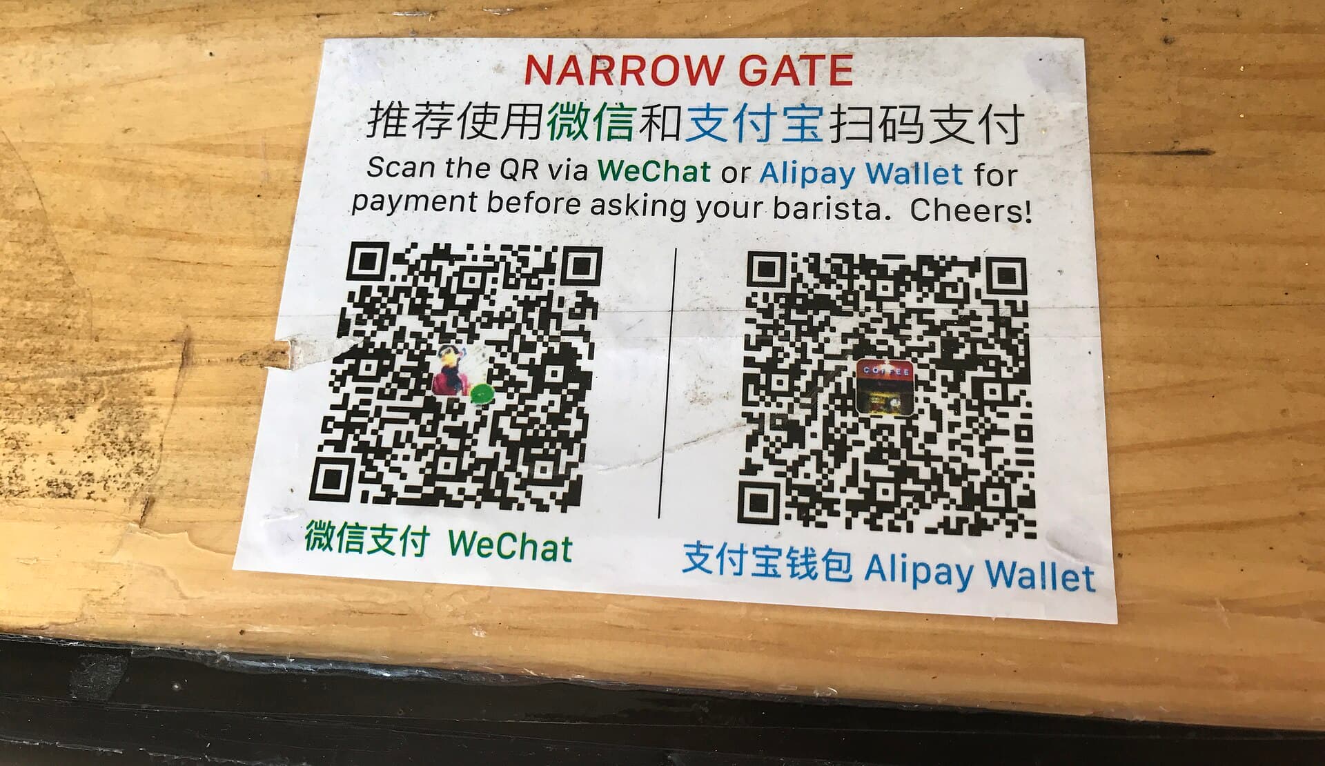 Weixin Pay and Alipay QR codes displayed together on a counter in China.