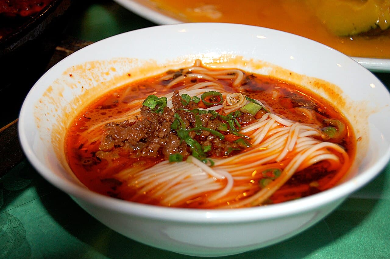 Noodles in a red chilli-oil broth topped with minced meat and spring onion
