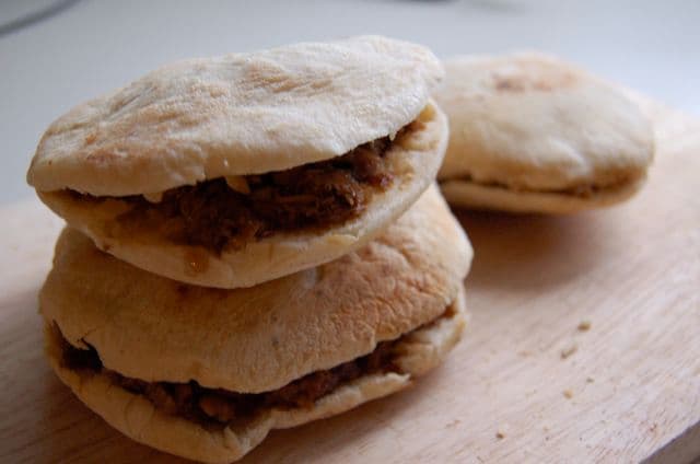 Flatbread buns split and filled with shredded braised meat